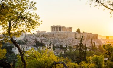Beautiful Acropolis perched above the city, framed by the green of trees.