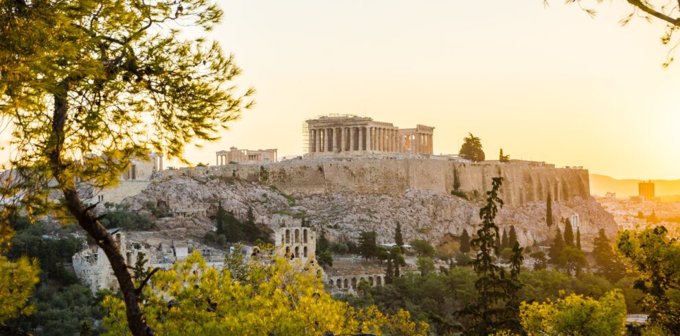 Beautiful Acropolis perched above the city, framed by the green of trees.