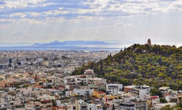 An Athens cityscape with the sea in the background.