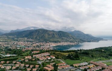 Aerial shot of town beside Lake Garda with mountains in the background