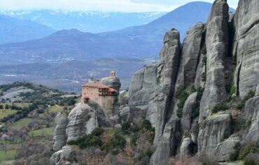 meteora atop rocks with mountains in background