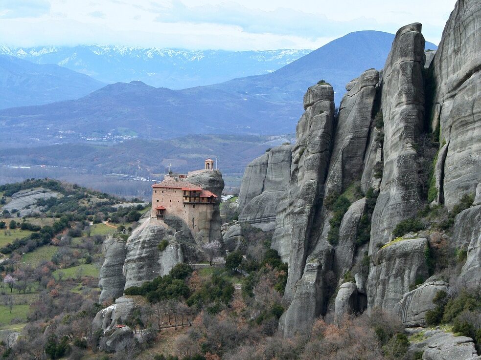 meteora atop rocks with mountains in background