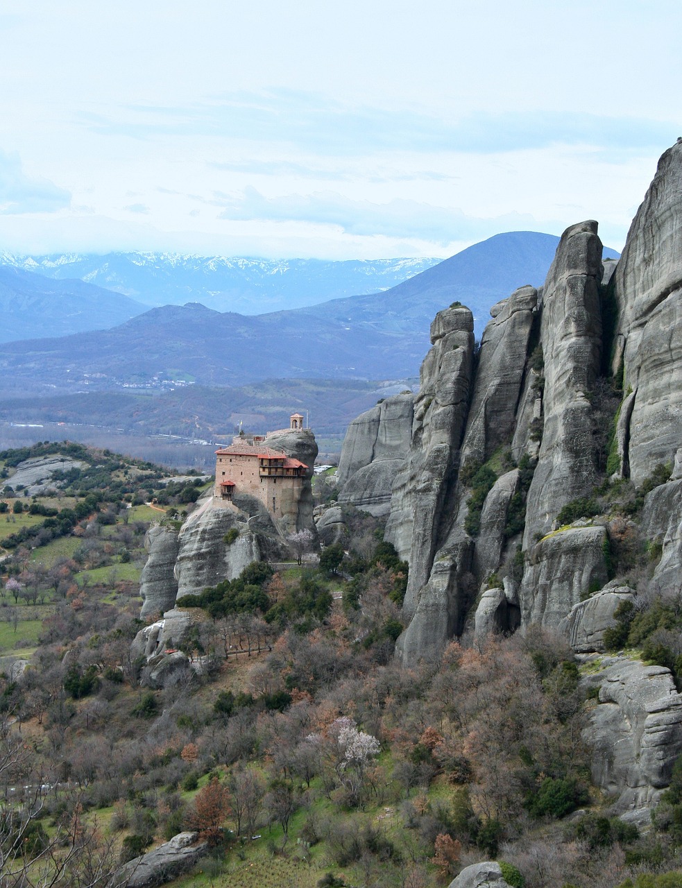 meteora atop rocks with mountains in background