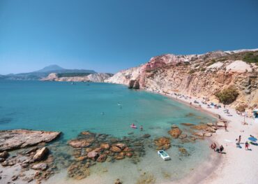 Firiplaka beach stretches far with the red cliffs towering over the beach.