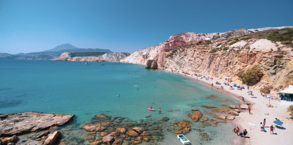 Firiplaka beach stretches far with the red cliffs towering over the beach.